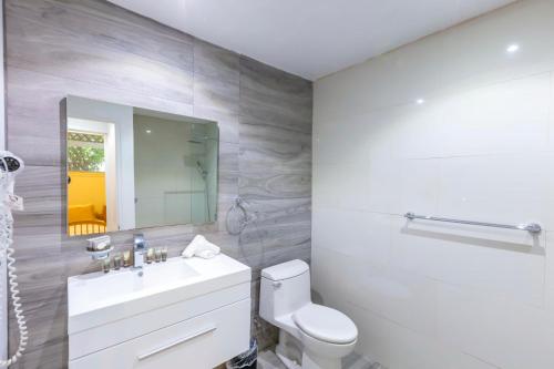 ein Badezimmer mit einem Waschbecken, einem WC und einem Spiegel in der Unterkunft Club Seabourne Hotel in Culebra