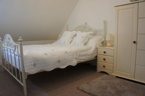 a bedroom with a bed with white sheets and pillows at The annex, Ruthvose in Saint Columb Major