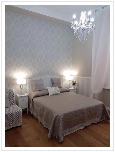 a bedroom with a large bed and a chandelier at Casa De Rose in Rome