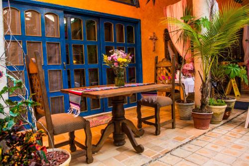 a table with chairs and a vase of flowers on it at Hacienda Boutique B&B and Spa Solo Adultos in Cozumel