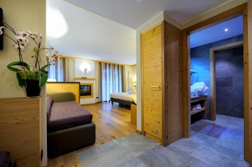 a hotel room with a bed and a couch at Boutique Hotel Diana in Madonna di Campiglio
