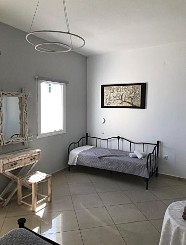 a bedroom with a bed and a mirror and a table at Lefteris Traditional Rooms in Fira