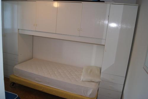 a small room with a bed and white cabinets at Appartamento l'Adriatico, Villarosa in Alba Adriatica