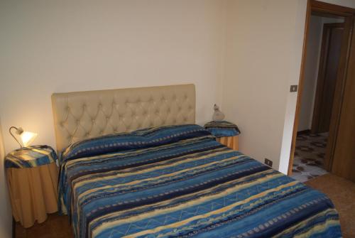 a bedroom with a bed with a blue and yellow striped blanket at Appartamento l'Adriatico, Villarosa in Alba Adriatica
