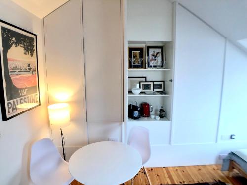 een witte tafel en twee witte stoelen in een kamer bij Camden Town House in Londen