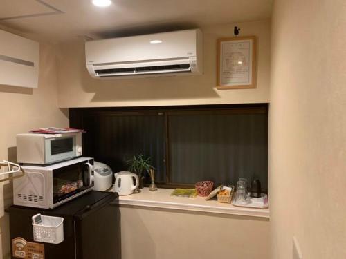 a kitchen with a microwave and a counter top at FUUTEI Japanese-style lodge in Kyoto