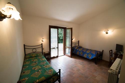 a room with two beds and a sliding glass door at Agriturismo La Piantata in Bolsena