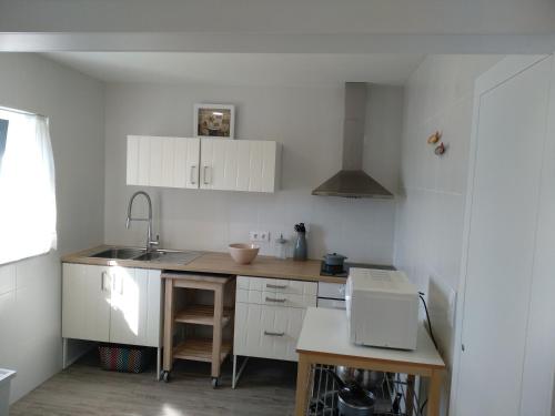 a kitchen with white cabinets and a sink at Casas do Pedro T3 in Vila Praia de Âncora