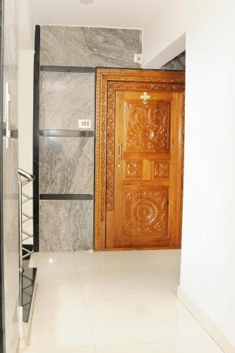 a wooden door in a room with a staircase at Single Bedroom to rent in Two bedroom apartment in Udupi