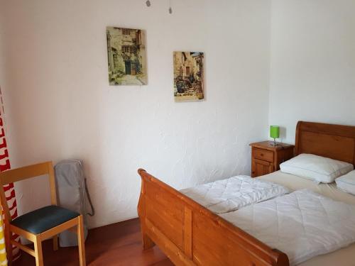 a bedroom with a bed and a chair in it at Haus Marlene in Zell an der Mosel