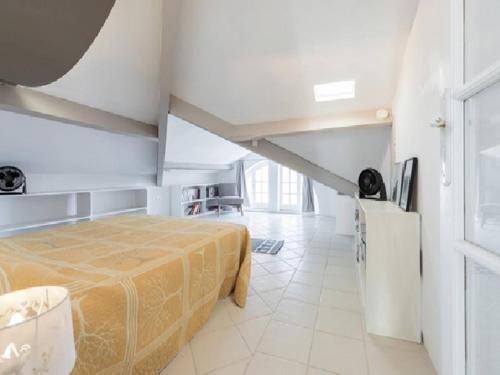 une chambre avec un lit dans une pièce blanche dans l'établissement Les Citronniers, à Villefranche-sur-Mer