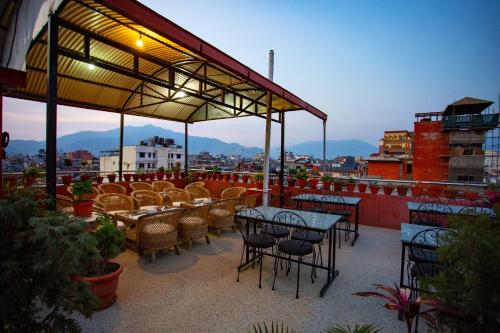 un patio con mesas y sillas en la azotea en Hotel Jay Suites, en Katmandú