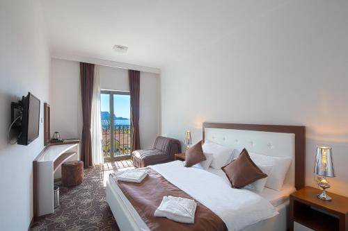 a hotel room with a bed and a chair at Hotel Pozzo in Budva