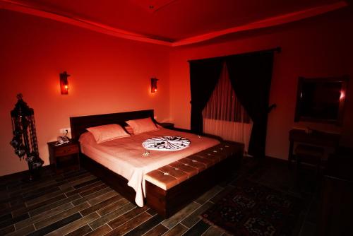 a bedroom with a bed in a red room at EL NAZAR STONE SUİTE in Uchisar