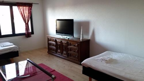 pokój z telewizorem na komodzie z łóżkiem w obiekcie Fjord Hostel Rooms w mieście Lysekil