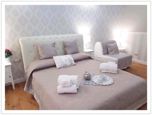 a bedroom with a large bed and a chair at Casa De Rose in Rome