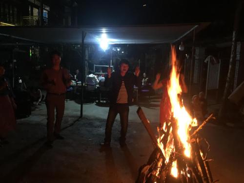 a group of people standing around a bonfire at night at Nobita Homestay bắc hà in Bắc Hà