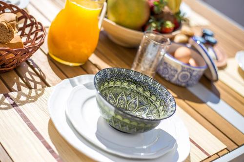 a table with a bowl on a plate and a bowl of food at Euphoria Luxury apartment in Faliraki