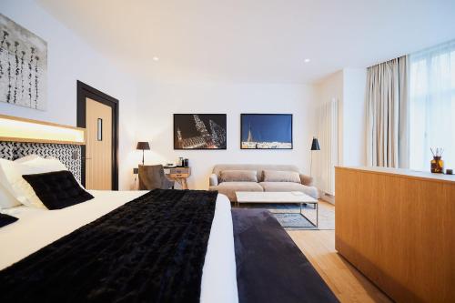 una camera d'albergo con letto e divano di B&B Suites 124 a Bruxelles