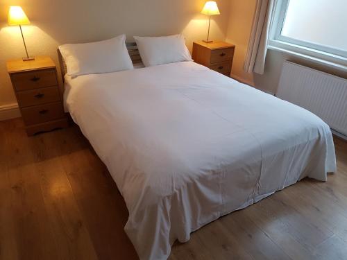 伯恩茅斯的住宿－博斯庫姆礁酒店，一张大白床,位于带两盏灯的房间