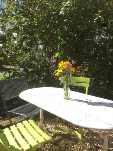 a table with a vase of flowers and two chairs at Gîte les Mineurs in Zottegem