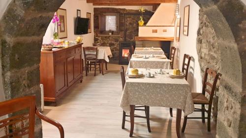 una sala da pranzo con 2 tavoli e una cucina di The Templars Guesthouse a Santu Lussurgiu