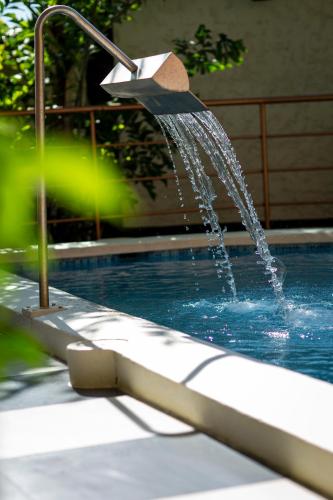 a swimming pool with a water fountain at Sumaj Casa Hotel in Tarapoto