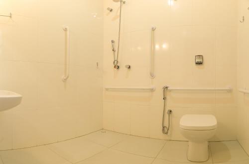 a white bathroom with a toilet and a sink at Hostel SLG in Maringá