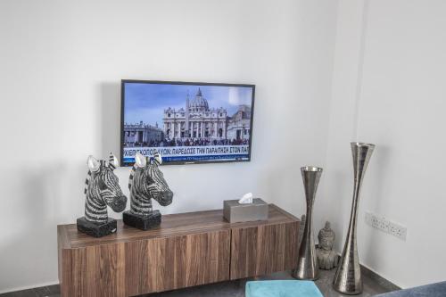 a living room with vases and a tv on a wall at Marimar villa in Protaras