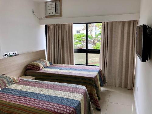 サルバドールにあるOndina Apartのベッドが2つと窓があるホテルの部屋