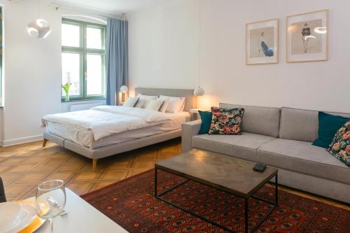 een woonkamer met een bank en een bed bij PROVENIR HOME STRZELECKA 25 in Poznań