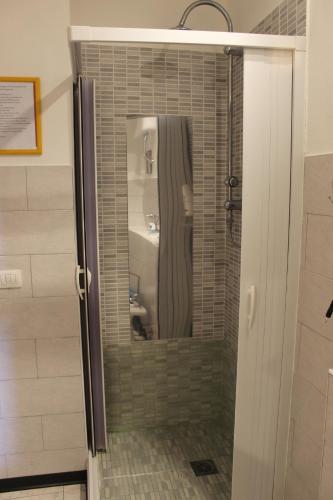 bagno con doccia, specchio e lavandino di B&B Su Nuraghe a SantʼAntìoco