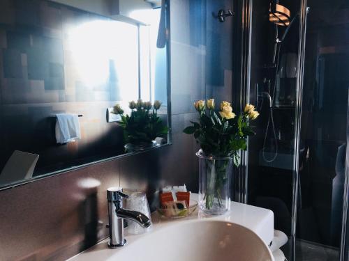a bathroom sink with a vase of flowers on it at Hotel Kristal 3 Stelle Superior in Zan&egrave;