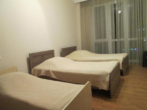 Cette chambre comprend 3 lits et une fenêtre. dans l'établissement Apartment Mandarina, à Kobuleti
