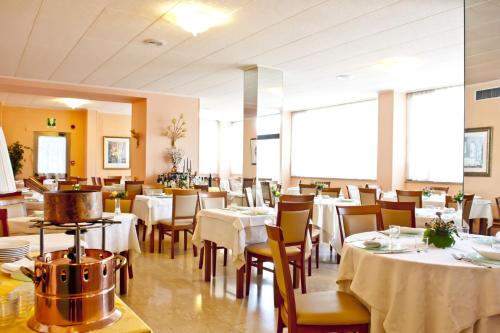 a restaurant with tables and chairs with white tablecloths at Ilgo Hotel in Perugia