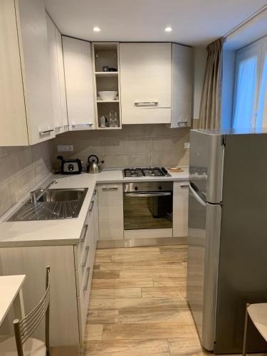 a kitchen with white cabinets and a stainless steel refrigerator at Ca du Sergio - Il Mesco in Levanto