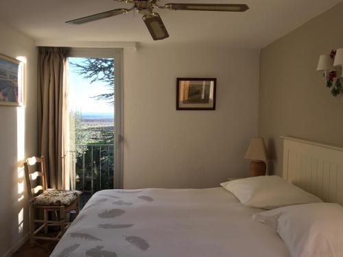 a bedroom with a bed and a large window at Hotel Bellerive in Rasteau