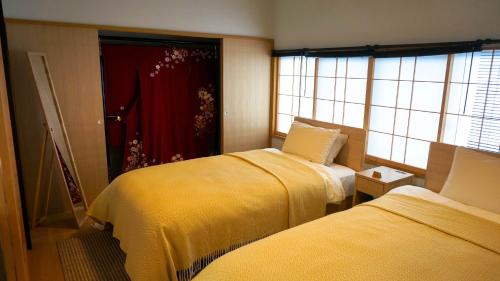 a room with two beds and a red curtain at Hotel Yori Toya / Vacation STAY 24393 in Kyoto