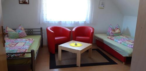 a room with two beds and a chair and a table at Ferien in Sachsen in Bischofswerda