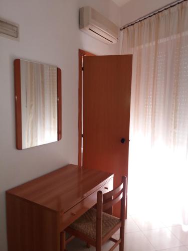 Habitación con escritorio con espejo y silla. en Hotel Europa en Vittoria