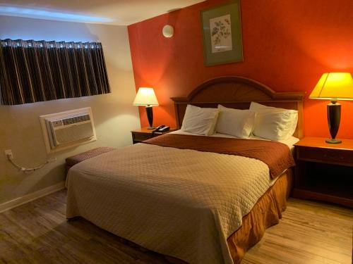 a hotel room with a bed and two lamps at Scottish Inn and Suites - Bensalem-Philadelphia in Bensalem