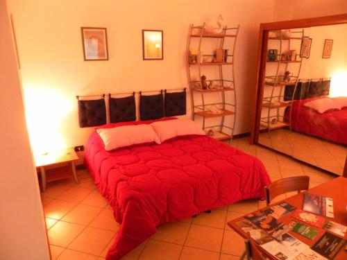 a bedroom with a bed with a red comforter at Appartamento Madonnina in Trieste