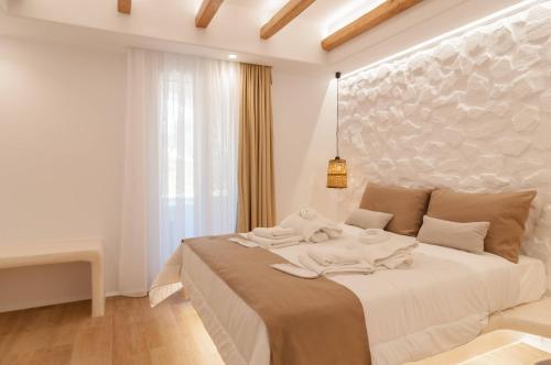 a white bedroom with a large bed with towels on it at Villa Adriana Hotel in Agios Prokopios