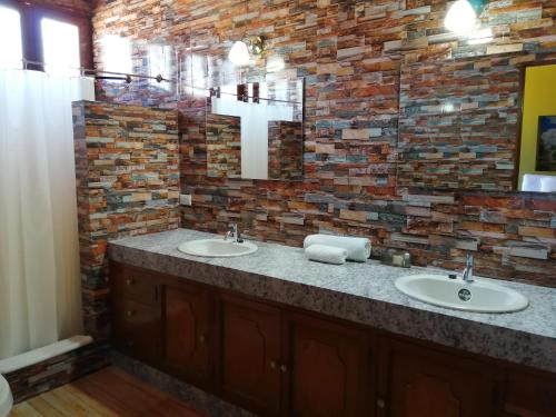 a bathroom with two sinks and a brick wall at Kartagus Hotel in San Salvador