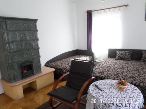 a bedroom with a bed and a chair and a fireplace at Rita apartman in Szombathely