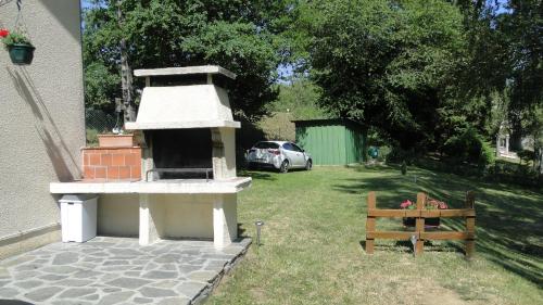 a bird house and a bench in a yard at Maison Lac de Pareloup -LES PIEDS DANS L'EAU- in Arvieu