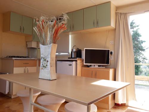 a kitchen with a table and a vase with flowers at A Deolinda in Santiago do Cacém