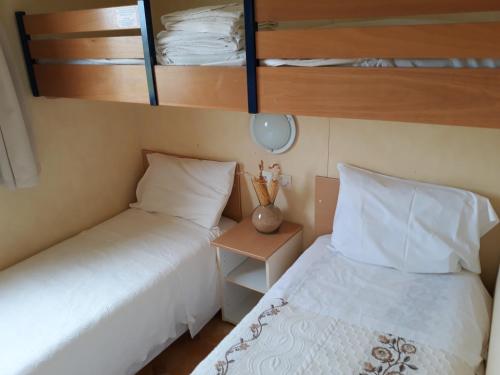 a bedroom with two beds and a night stand with a bed sqor at A Deolinda in Santiago do Cacém