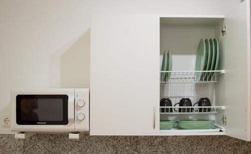 un microondas en una cocina con algunos platos en Apartamentos Océanos, en Málaga