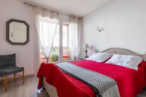 Schlafzimmer mit einem roten Bett, einem Spiegel und einem Stuhl in der Unterkunft Cassis centre- Entre Falaise et Port in Cassis